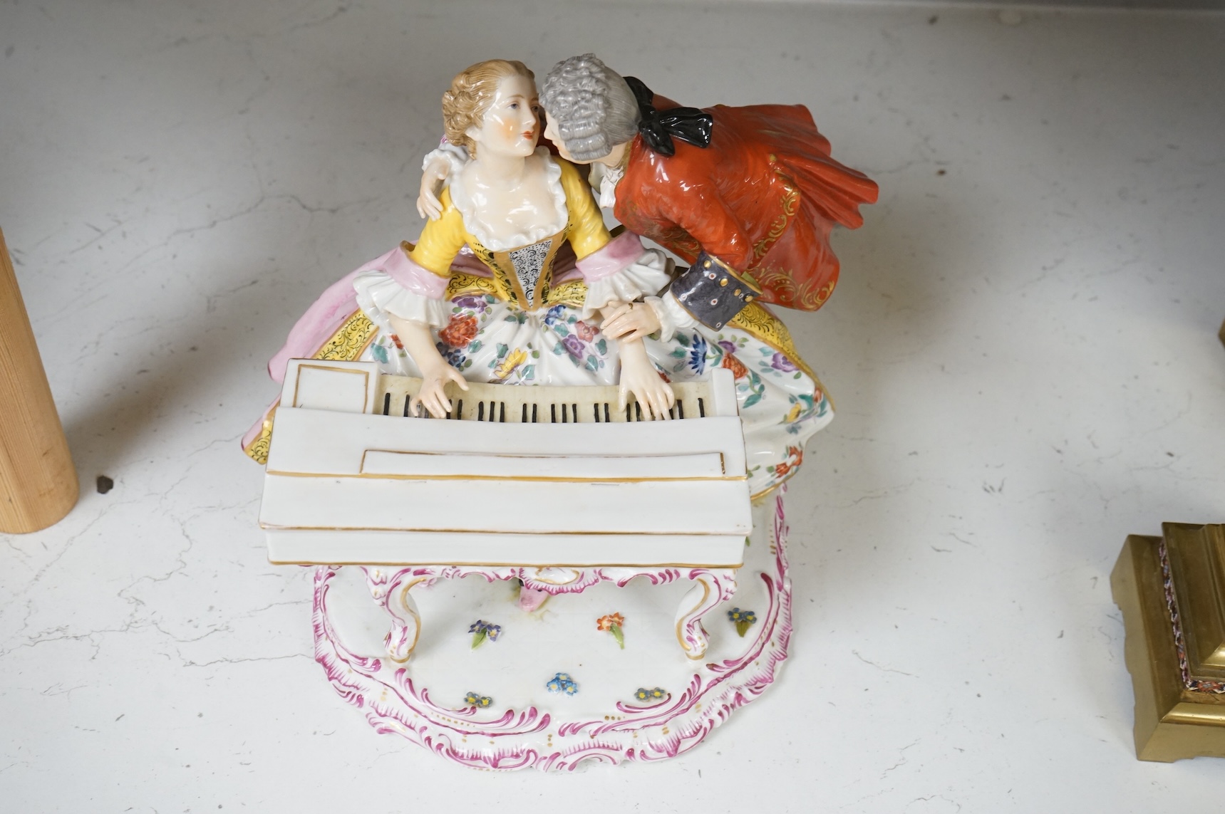 A large German porcelain group lovers at a piano, 22cm high